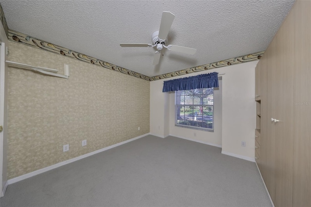 unfurnished room with ceiling fan, carpet floors, and a textured ceiling