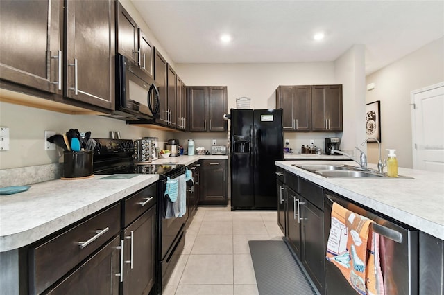 kitchen with sink, light tile patterned floors, black appliances, and dark brown cabinets