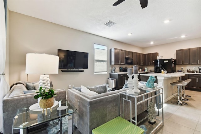 tiled living room featuring ceiling fan