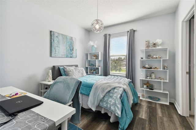 bedroom with dark hardwood / wood-style flooring and a textured ceiling