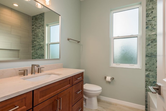 bathroom with vanity, a wealth of natural light, and toilet