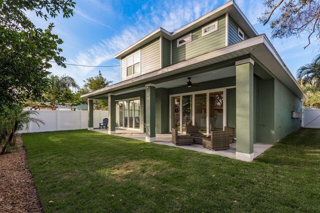 rear view of property with a patio area, ceiling fan, and a lawn