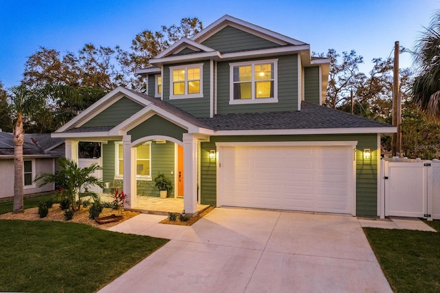 craftsman-style home featuring a garage and a lawn