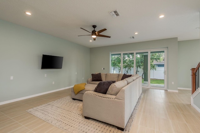 living room featuring ceiling fan, a textured ceiling, and light tile patterned floors