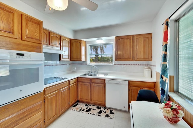 kitchen with tasteful backsplash, white appliances, ceiling fan, sink, and light tile patterned floors