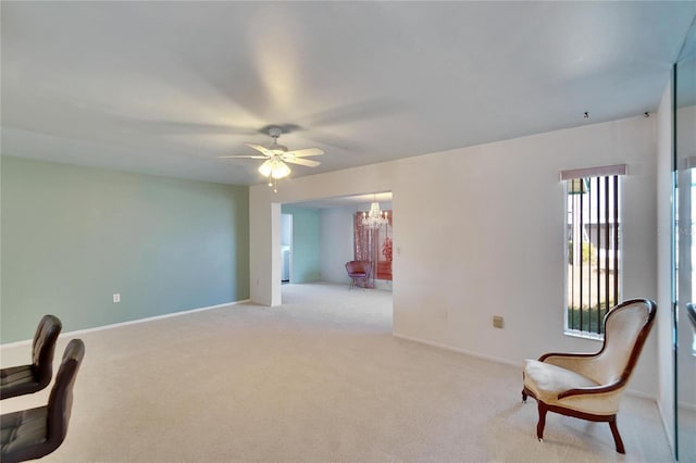 living area featuring light carpet and ceiling fan with notable chandelier