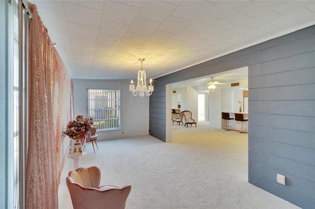 dining room featuring ceiling fan with notable chandelier and light carpet