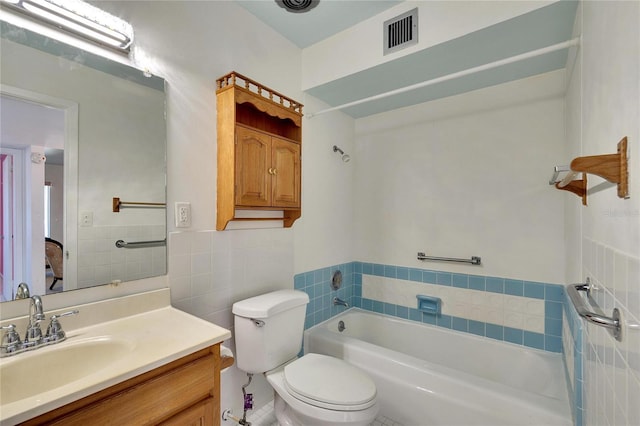 bathroom featuring a tub to relax in, vanity, tile walls, and toilet