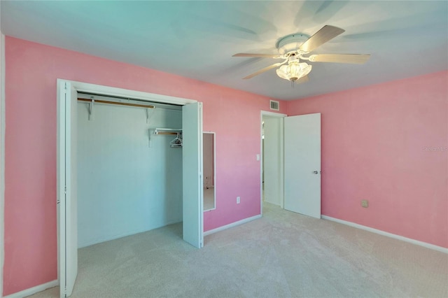 unfurnished bedroom with ceiling fan, a closet, and light carpet