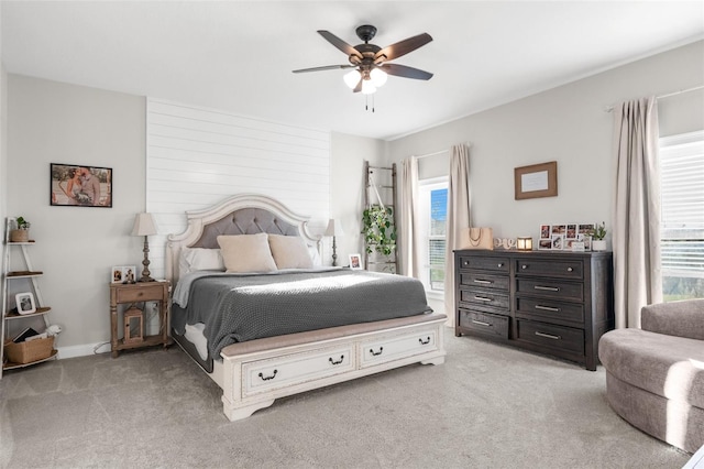 bedroom with light carpet, a ceiling fan, and baseboards