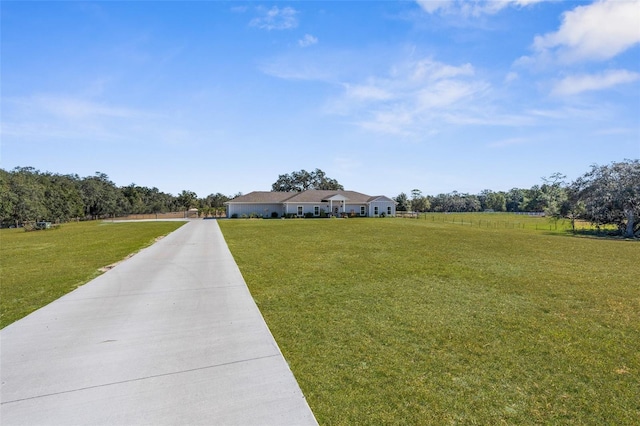 view of road with concrete driveway and a rural view