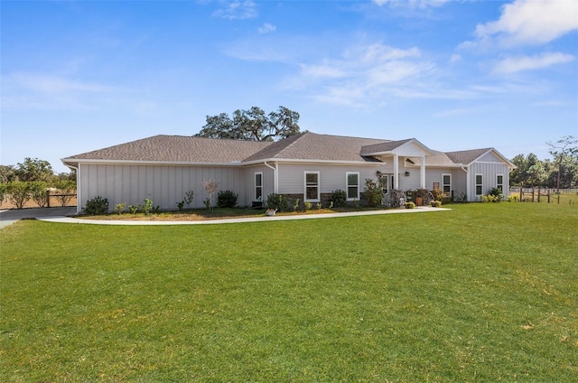 view of front of house with board and batten siding and a front lawn