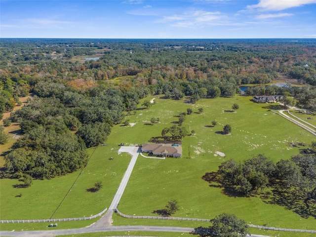 drone / aerial view featuring a rural view and a view of trees