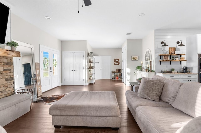 living room with dark wood-style floors, visible vents, and french doors