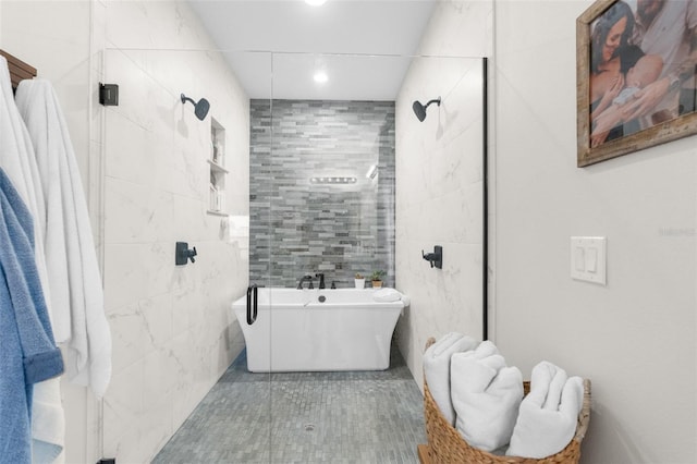 bathroom featuring a freestanding tub, tiled shower, tile walls, and tile patterned floors