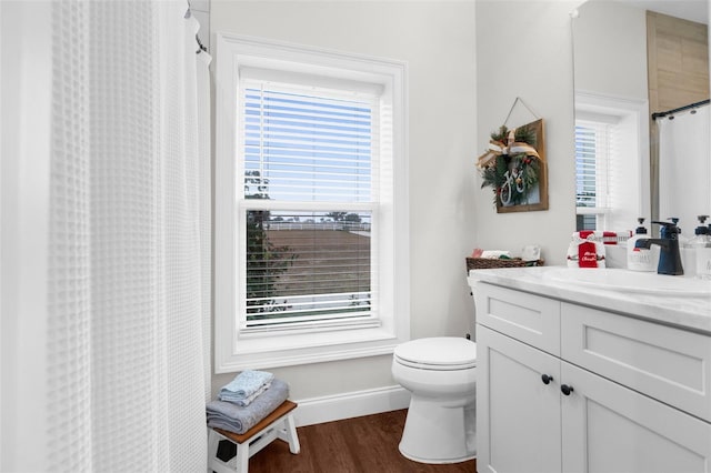 bathroom with toilet, a shower with shower curtain, wood finished floors, vanity, and baseboards