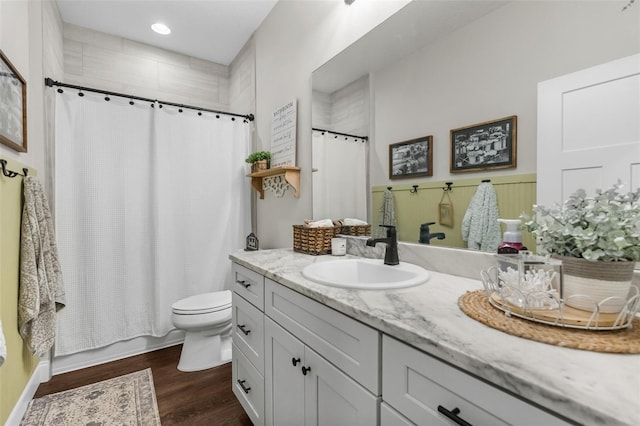 bathroom featuring toilet, recessed lighting, wood finished floors, and vanity