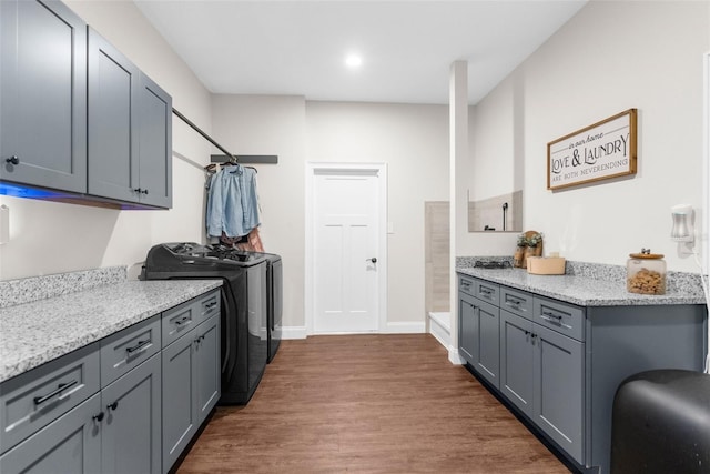 laundry room with washing machine and dryer, cabinet space, dark wood finished floors, and baseboards