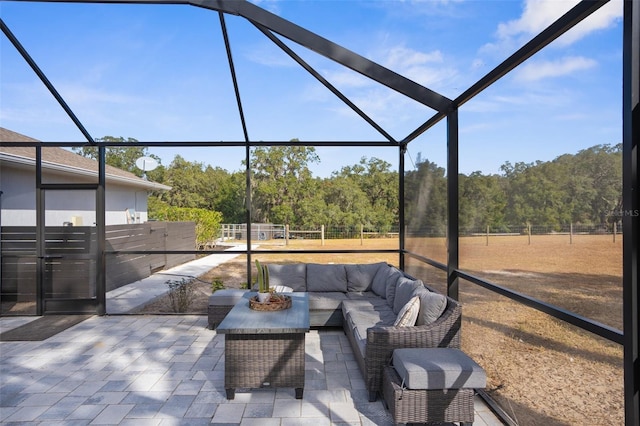 view of patio with a lanai, fence, and an outdoor living space