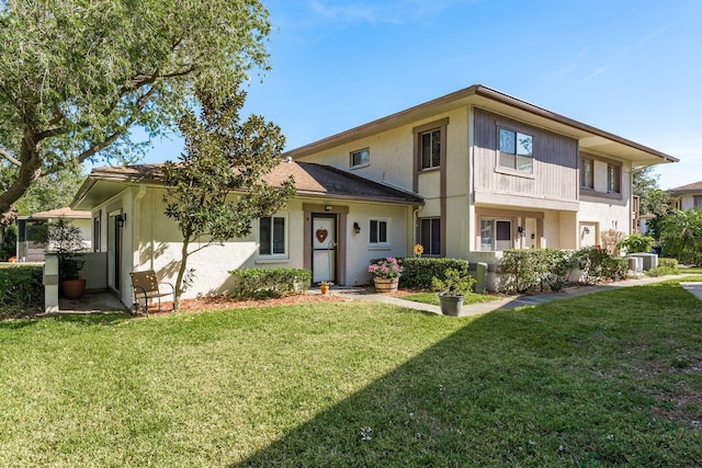 view of front of house with central AC and a front lawn