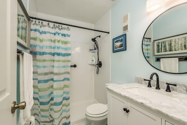 bathroom with toilet, vanity, and a shower with shower curtain