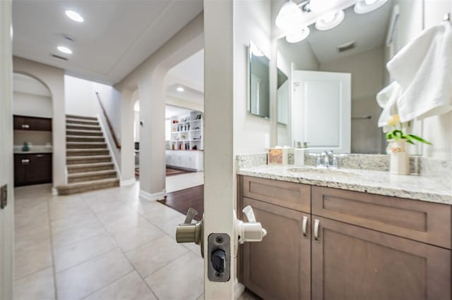 bathroom with tile patterned floors, vanity, and vaulted ceiling