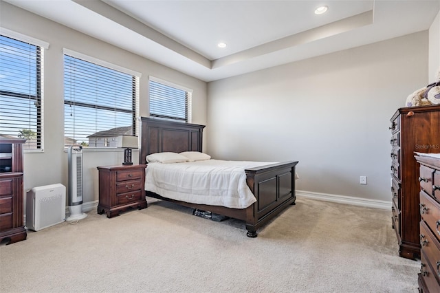 carpeted bedroom featuring a tray ceiling