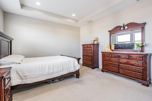 carpeted bedroom with a raised ceiling