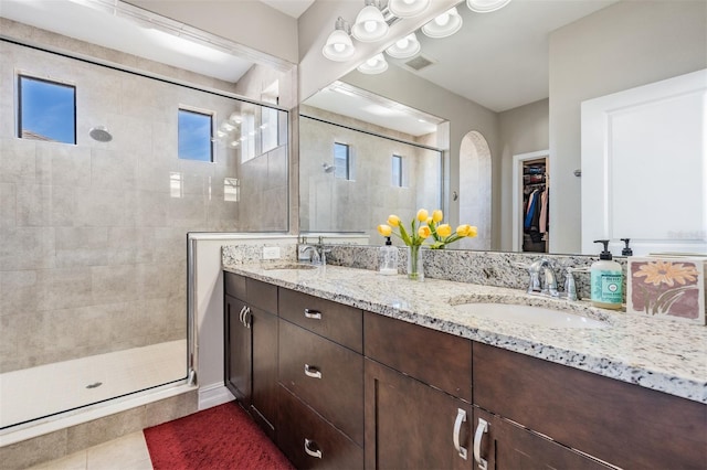 bathroom with tile patterned floors, vanity, and walk in shower