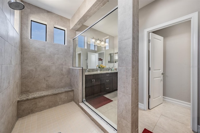 bathroom with tile patterned flooring, vanity, and tiled shower