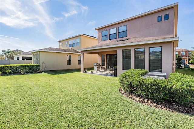 back of property with a patio area and a yard