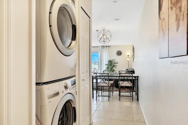 19811 Gulf Blvd Unit 102, Indian Shores, FL 33785 - laundry area featuring estacked washer and dryer, light tile patterned floors, baseboards, and a chandelier