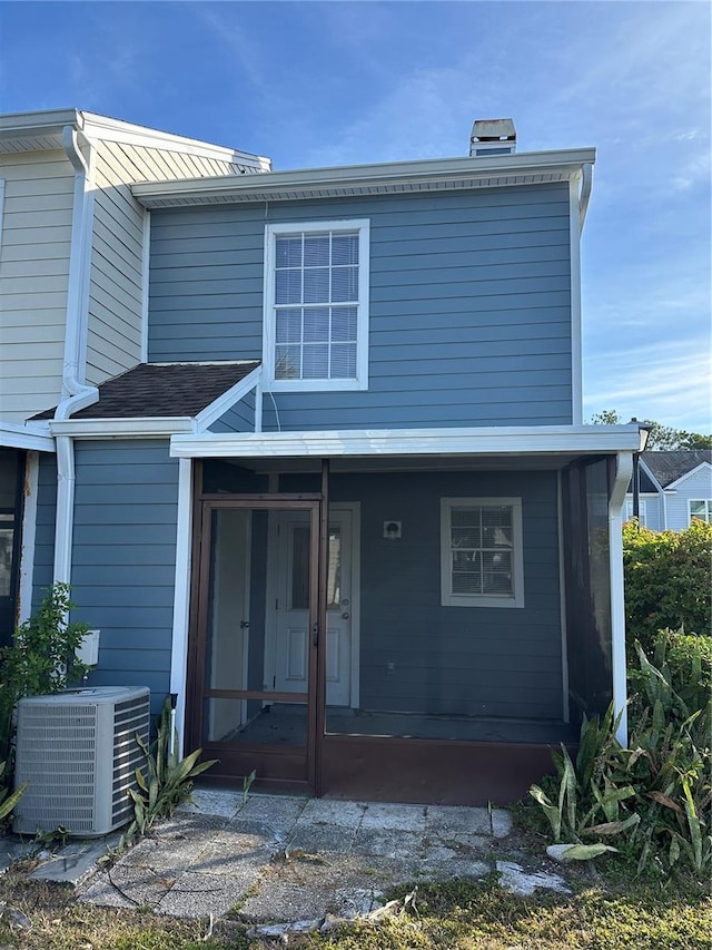 view of front of home featuring a sunroom and central AC