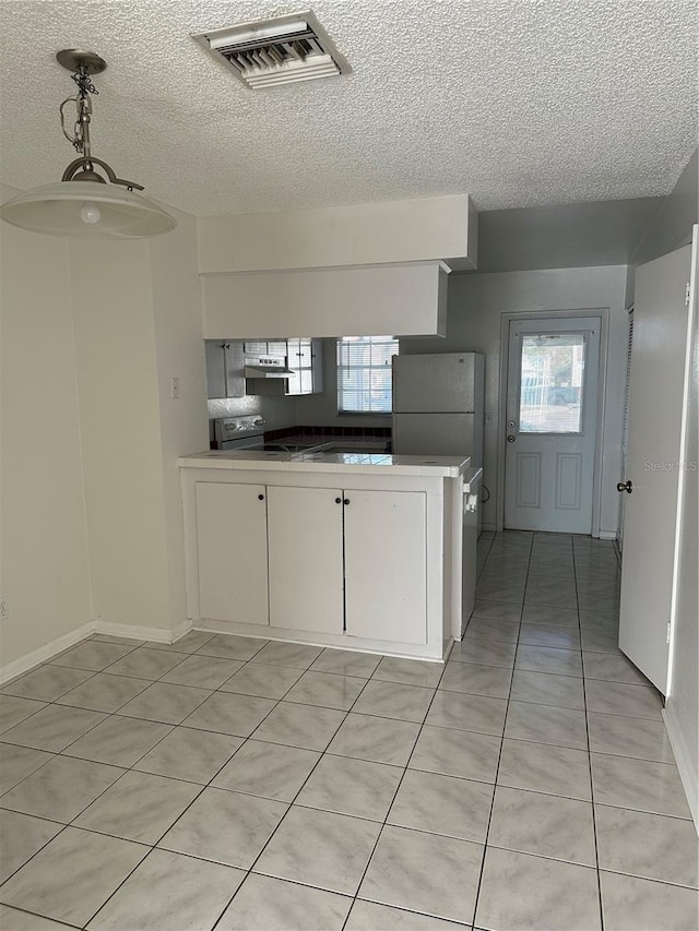 kitchen with stainless steel range with electric stovetop, white cabinets, white refrigerator, hanging light fixtures, and light tile patterned flooring