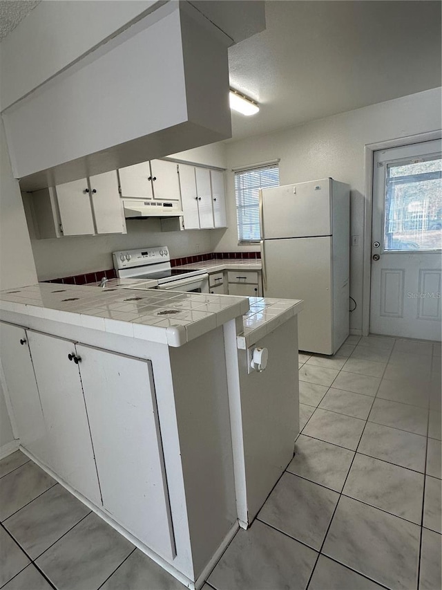 kitchen featuring white cabinets, a healthy amount of sunlight, white appliances, and kitchen peninsula