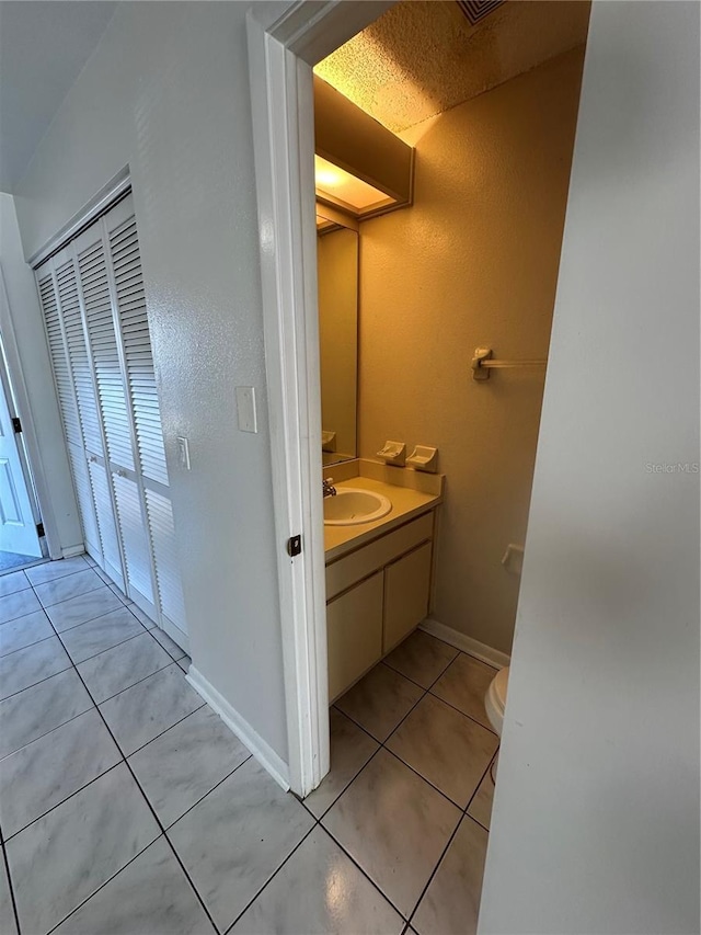 bathroom featuring toilet, vanity, and tile patterned floors