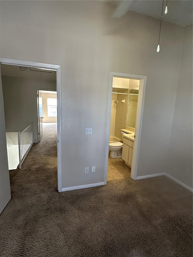 unfurnished bedroom featuring connected bathroom, high vaulted ceiling, light colored carpet, a walk in closet, and a closet