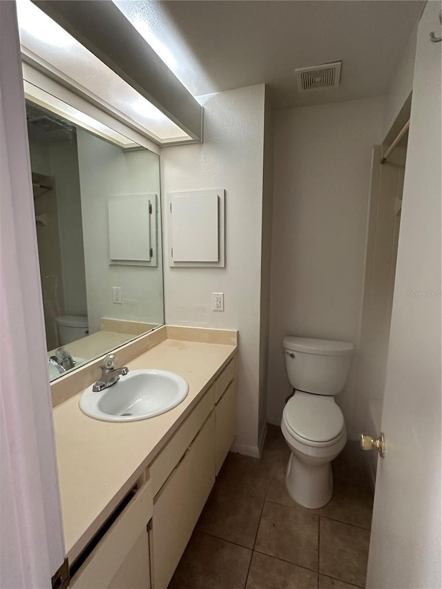 bathroom featuring tile patterned flooring, vanity, and toilet