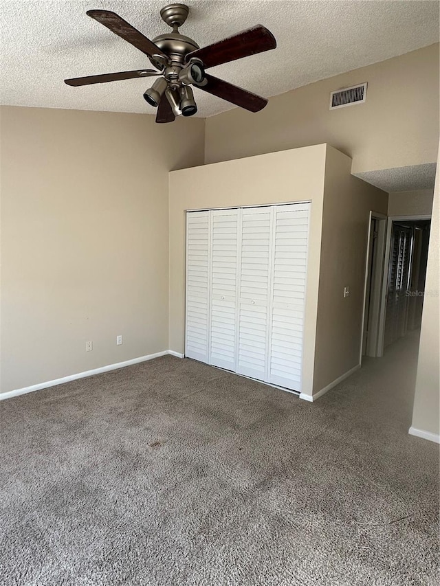 unfurnished bedroom featuring carpet, a textured ceiling, a closet, and ceiling fan