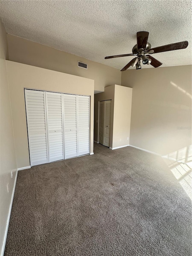 unfurnished bedroom with carpet, ceiling fan, and a textured ceiling