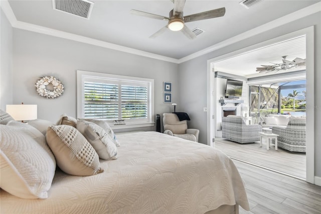 bedroom featuring ceiling fan, crown molding, and light wood-type flooring