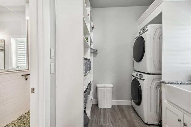 washroom with sink, cabinets, stacked washer and dryer, hardwood / wood-style floors, and tile walls