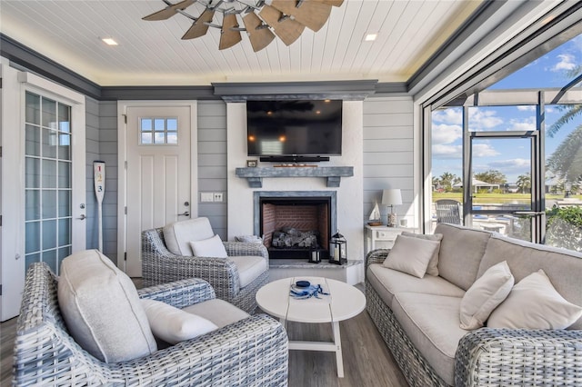 living room with wood-type flooring, a large fireplace, a wealth of natural light, and wooden ceiling