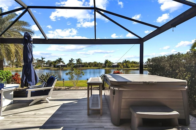 wooden terrace with a water view, a hot tub, and a lanai