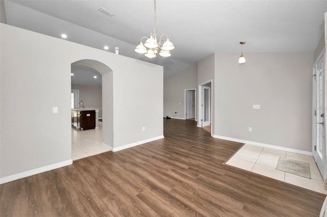 empty room featuring hardwood / wood-style flooring, sink, and a notable chandelier