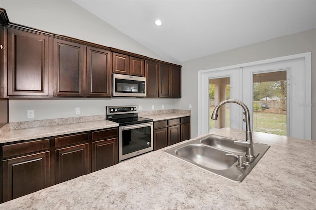 kitchen with dark brown cabinetry, sink, stainless steel appliances, and vaulted ceiling