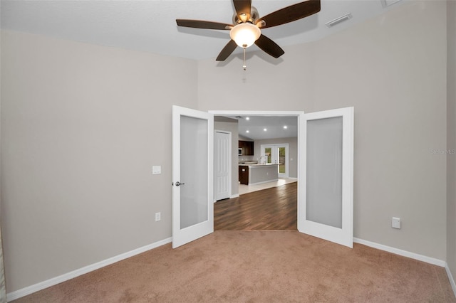 unfurnished room with ceiling fan, french doors, and carpet floors