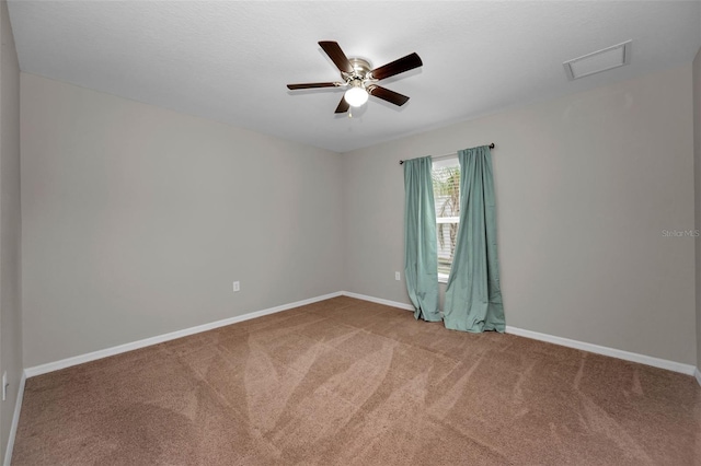 empty room featuring ceiling fan and carpet