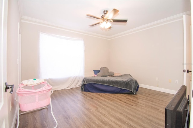 bedroom featuring hardwood / wood-style flooring, ceiling fan, and crown molding