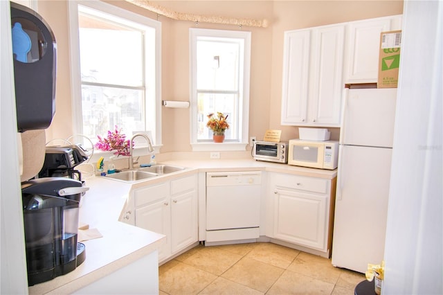 kitchen featuring white cabinets, white appliances, sink, and light tile patterned floors